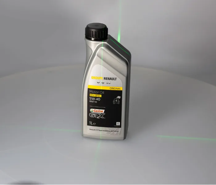 Motor oil bottle with the linear laser cross projected to mark the centre of rotation